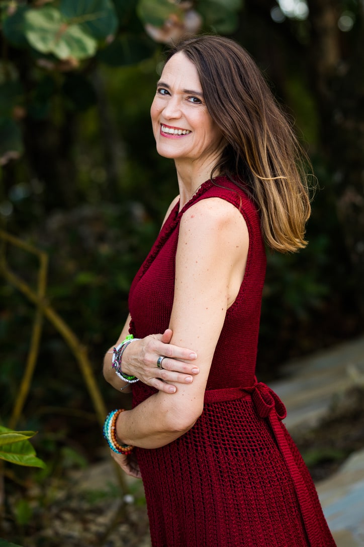 Woman in red dress smiling with plants in background